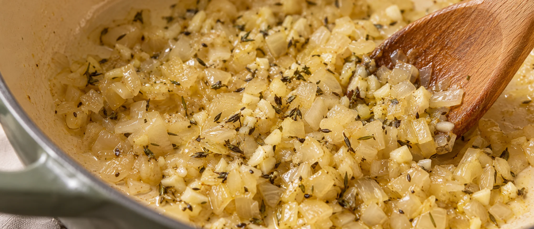 Softened translucent onion with garlic and herbs in a saucepan