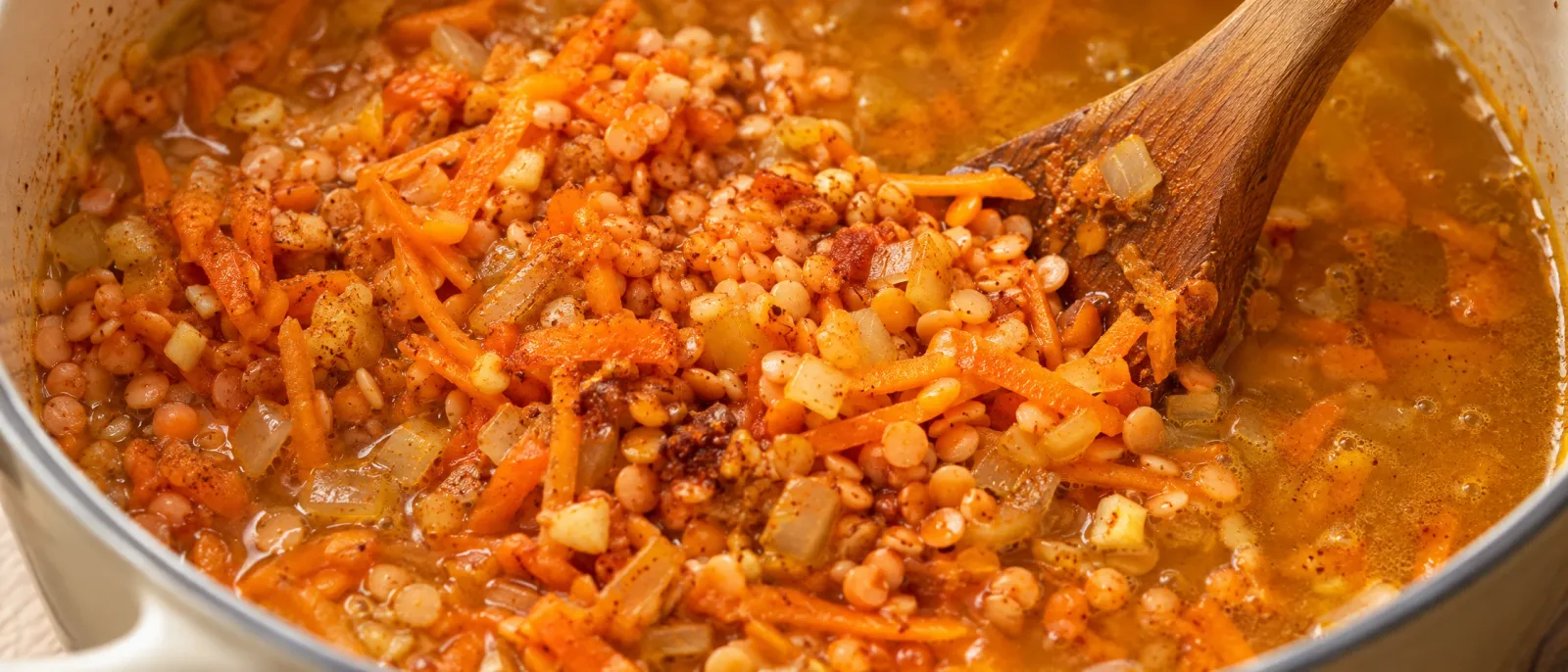 Red lentils with carrot, onion and spices in a saucepan