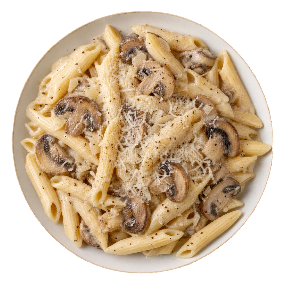 Makaron penne w kremowym sosie z rumianymi pieczarkami i startym parmezanem na jasnym talerzu.